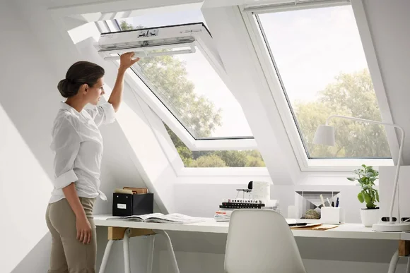 Person öffnet Dachfenster